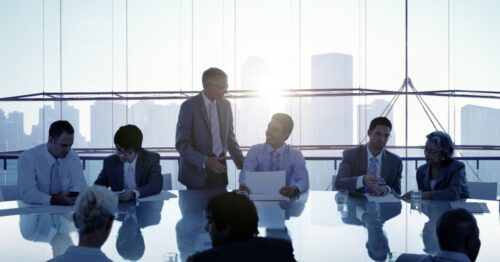 Board directors of various ethnicities and ages assemble in a boardroom